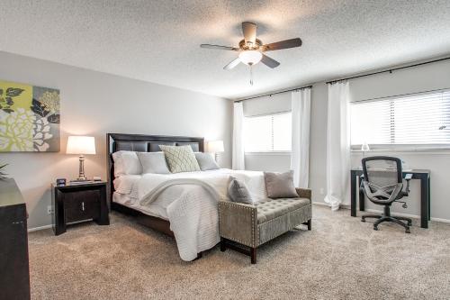 a bedroom with a bed and a chair and a ceiling fan at Super Fun House in Perfect Location in San Antonio