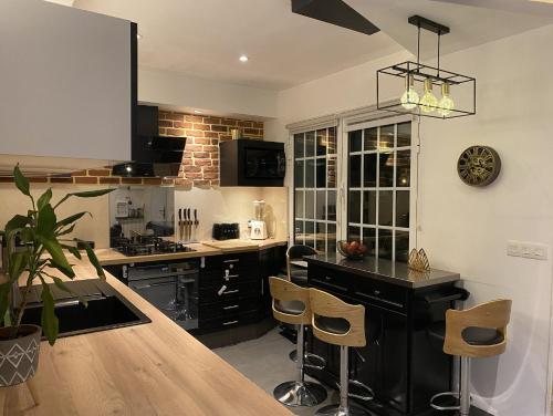 a kitchen with black cabinets and a counter top at Maison Lyon-Bron Eurexpo - Stadium Groupama in Bron