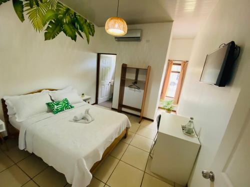 a bedroom with a bed and a television and a table at Ukinca in Uvita