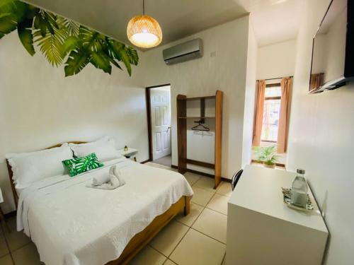 a bedroom with a large white bed and a table at Ukinca in Uvita