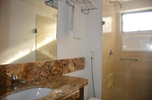 a bathroom with a sink and a shower at Suítes Natal Plaza - Apto 1812 in Natal