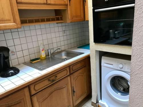 une cuisine avec un évier et une machine à laver dans l'établissement Exclusive building for groups, au Mans