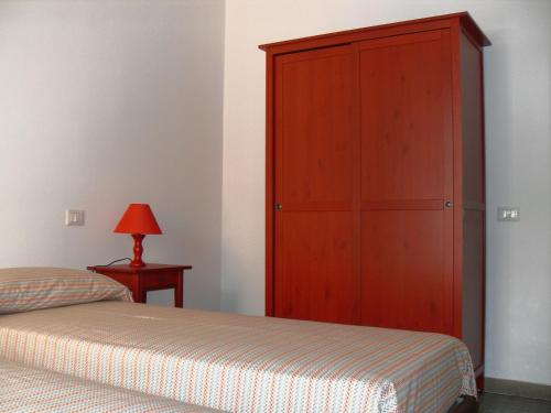 カリアリにあるFlamingo B&Bのベッドルーム1室(ベッドの横に大きな木製キャビネット付)