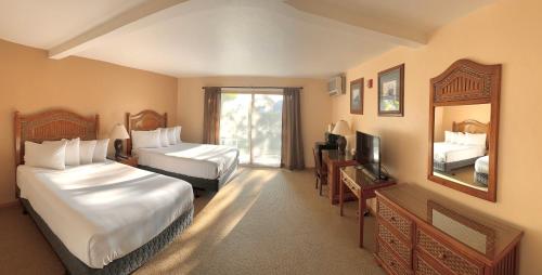 a hotel room with two beds and a mirror at The Lodge at Leathem Smith in Sturgeon Bay