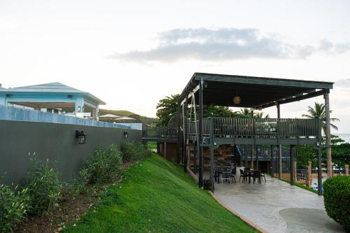 a house with a deck and a table and chairs at Hotel El Guajataca in Quebradillas