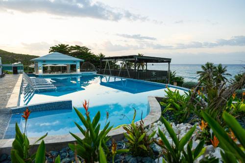 a swimming pool with the ocean in the background at Hotel El Guajataca in Quebradillas