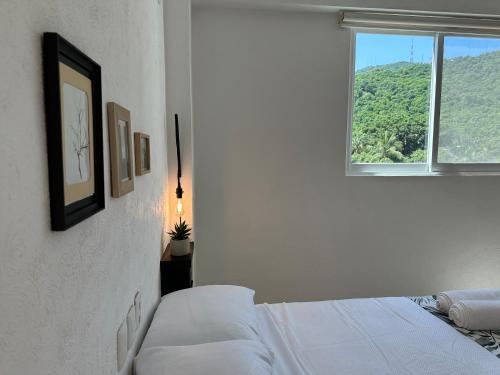 una camera bianca con un letto e una finestra di CLUB DE GOLF ad Acapulco