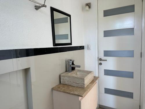 un bagno con lavandino, specchio e porta di CLUB DE GOLF ad Acapulco