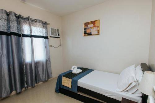 a small bedroom with a bed and a window at Bahay Ni Kikay Vacation Rental - WiFi Included in General Santos