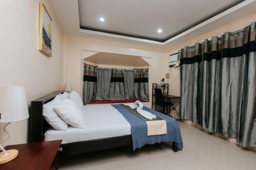 Schlafzimmer mit einem Bett, einem Schreibtisch und einem Fenster in der Unterkunft Bahay Ni Kikay Vacation Rental - WiFi Included in General Santos