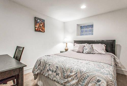 een slaapkamer met een bed en een bureau met een lamp bij Spacious & Stylish Home at the heart of Wicker Park in Chicago