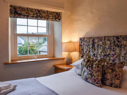 een slaapkamer met een bed en een raam bij Byways in Cartmel