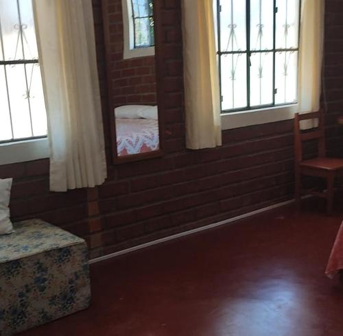 Cette chambre dispose d'un mur en briques et de deux fenêtres. dans l'établissement ALMÁZYGO Bed & Breakfast, à Tarapoto