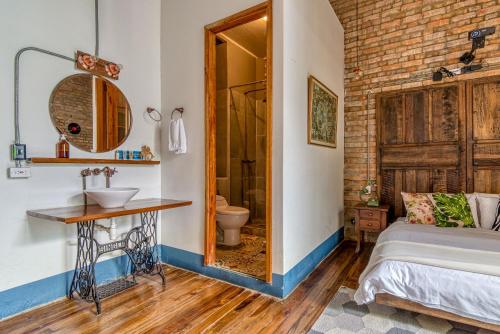 ein Bad mit einem Bett und einem Waschbecken in einem Zimmer in der Unterkunft Selina La Candelaria Bogotá in Bogotá