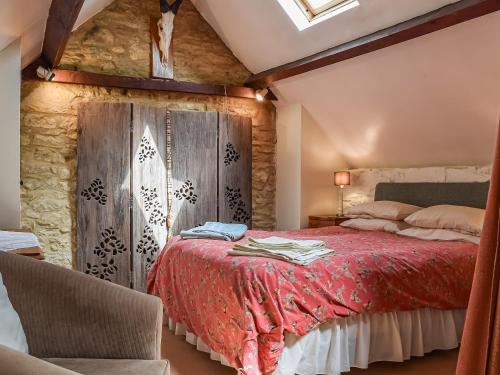 a bedroom with a red bed with a wooden wall at The Barn in Ramsden