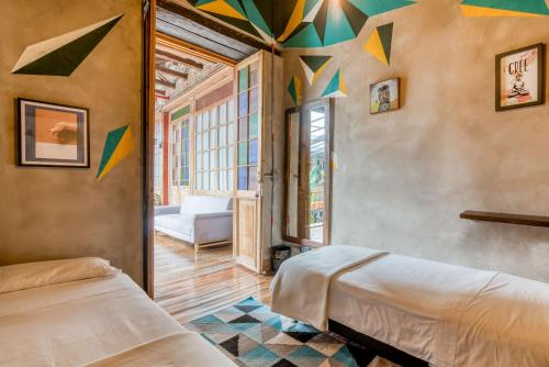 a bedroom with two beds and colorful ceilings at Socialtel Candelaria Bogotá in Bogotá