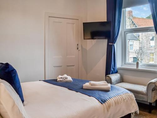 um quarto com uma cama com duas toalhas em The Hamilton Collection - Waterloo Place em Spittal