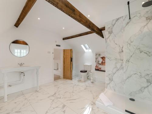 a white bathroom with a marble wall at The Farmhouse - Uk45171 in Southwell