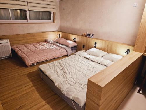 two beds in a room with wooden floors at Close to Gangnam, COEX & Luxury Apartment near Lotte world in Seoul