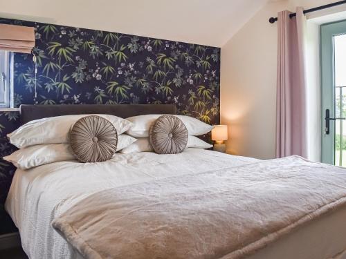 a bedroom with a large bed with a blue wall at Swiss Cottage in Scotforth