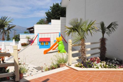 a childs playground with a toy in the sand at Coral Hotel & Resort in Vlorë