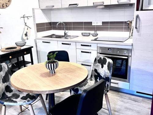 une cuisine avec une table, des chaises et un évier dans l'établissement Appartement charmant, 1 chambre, parking privé, WiFi - Les Gets - FR-1-671-144, aux Gets
