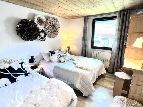 une chambre avec deux lits et une fenêtre dans l'établissement Appartement au cœur des Gets, proche des remontées, 2 chambres, 5 pers, Wi-Fi, parking privé - FR-1-671-44, aux Gets