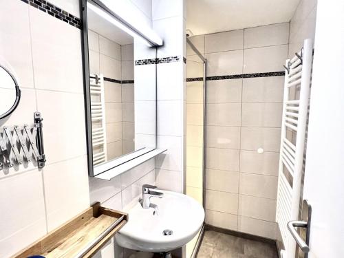une salle de bain blanche avec un lavabo et un miroir dans l'établissement Appartement au cœur des Gets, proche des remontées, 2 chambres, 5 pers, Wi-Fi, parking privé - FR-1-671-44, aux Gets