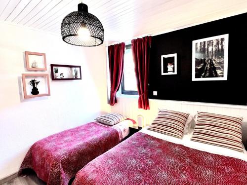 - 2 lits dans une chambre avec des draps rouges et violets dans l'établissement Appartement charmant, 1 chambre, parking privé, WiFi - Les Gets - FR-1-671-144, aux Gets