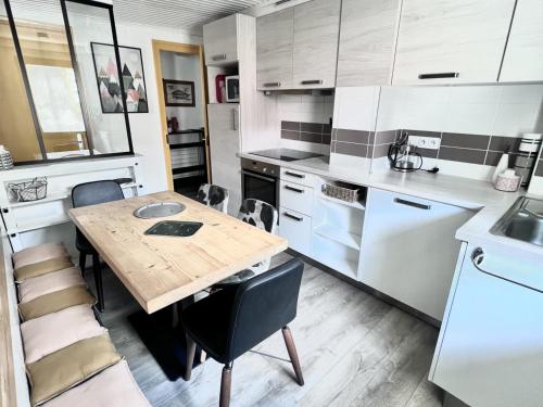 Il comprend une cuisine avec une table et des chaises en bois. dans l'établissement Appartement cosy au cœur des Gets, proche des télécabines, 2 chambres, Wi-Fi, parking privatif - FR-1-671-124, aux Gets