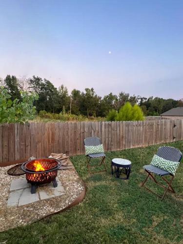 a backyard with two chairs and a fire pit at Pet Friendly, King Bed, Fire Pit in Tyler