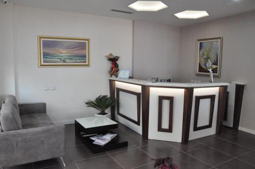 a waiting room with a couch and a counter at Coral Hotel & Resort in Vlorë