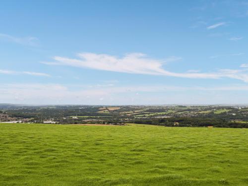 a green field with a view of a city at North Moor Farm Shepherds Hut in Bradley