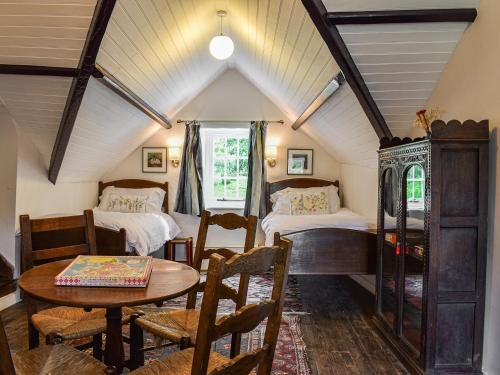 a room with two beds and a table and chairs at Needle House in Ravenstonedale