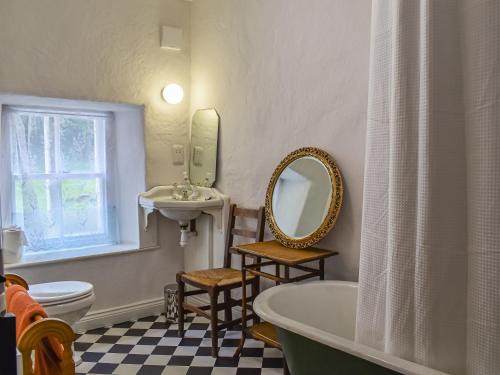 a bathroom with a tub and a sink and a mirror at Needle House in Ravenstonedale