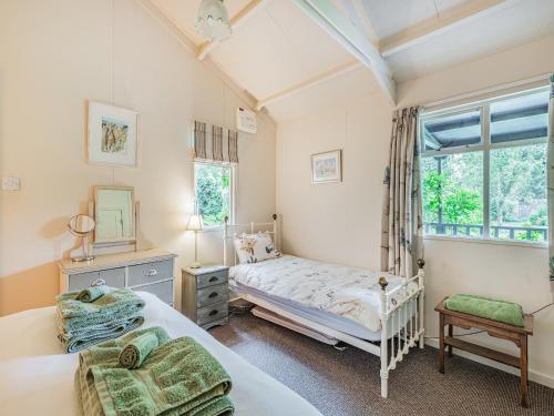 a bedroom with two beds and a window at Peaceful Woodland Lodge in Cornisholme