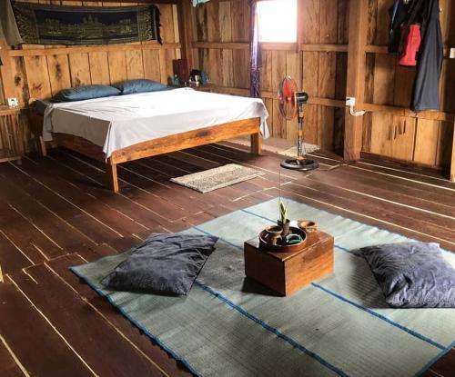 um quarto com uma cama e duas almofadas no chão em Dragonfly Guesthouse em Koh Rong Sanloem