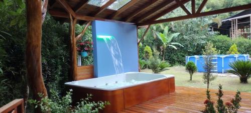 a bath tub on a wooden deck with a fountain at The Wooden House Mindo in Mindo