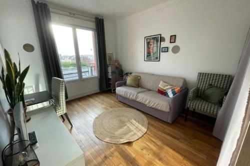 Peaceful studio nearby Paris في بانتين: غرفة معيشة مع أريكة وطاولة