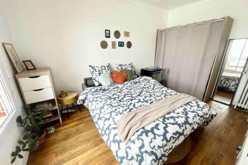 um quarto com uma cama com um edredão azul e branco em Peaceful studio nearby Paris em Pantin