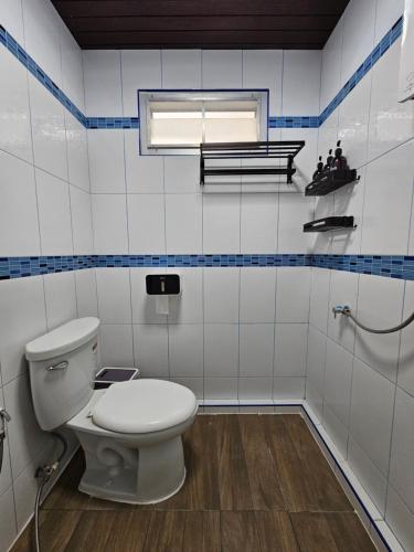 a bathroom with a white toilet and a window at Anda Betong Homestay in Ban Komo Sip Paet