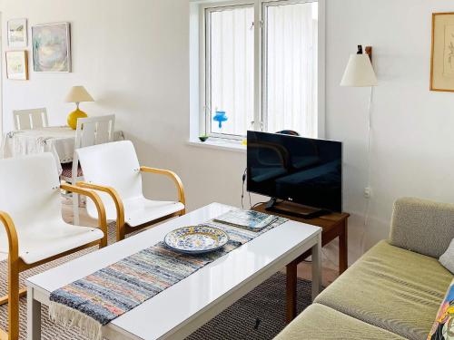 a living room with a table and a tv at 4 star holiday home in ELLÖS-By Traum in Ellös