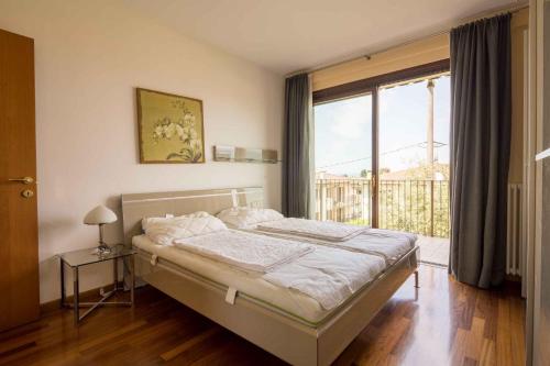 a bedroom with a bed and a large window at Apartment in Pacengo - Gardasee 45414 in Pacengo di Lazise