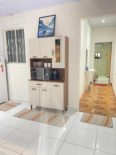 a kitchen with white cabinets and a counter at Napolitan House in Manaus