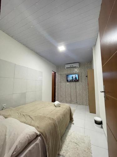 Napolitan House في ماناوس: غرفة نوم بسريرين وتلفزيون على الحائط