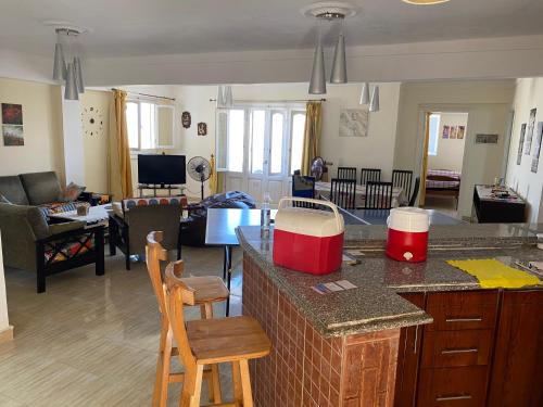 a kitchen and living room with a counter and chairs at شالية 180م بالروف 180م قرية هليوبيتش الساحل الشمالي للايجار للعائلات فقط in Dawwār ‘Abd al Qādir Qāsim