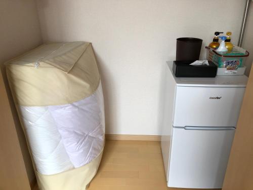 Habitación con cama y nevera pequeña. en I・ecoⅢ（アイエコスリー）, en Niigata