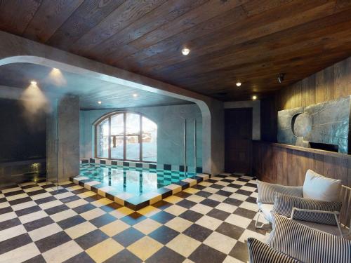 - une piscine dans une chambre avec un sol en damier dans l'établissement Chalet avec Piscine Chauffée, Accès Direct aux Pistes et Services de Luxe à Val-d'Isère - FR-1-567-108, à Val dʼIsère