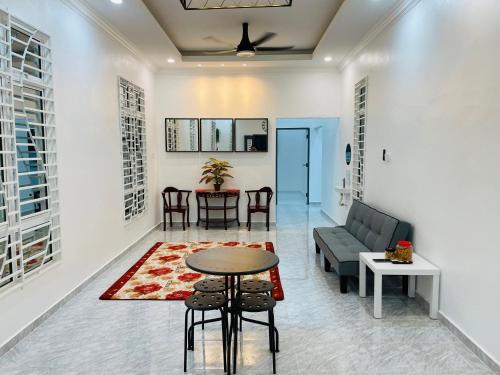 uma sala de estar com um sofá e uma mesa em Dhuha & Dharyl's Staycation em Kota Bharu