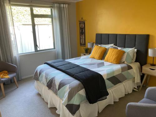 a bedroom with a large bed with yellow walls and a window at Kingsley Quarters in Cambridge